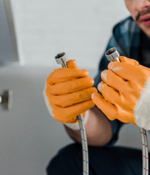 selective-focus-of-handyman-holding-metal-hose-nea-3RRB4SZ.jpg